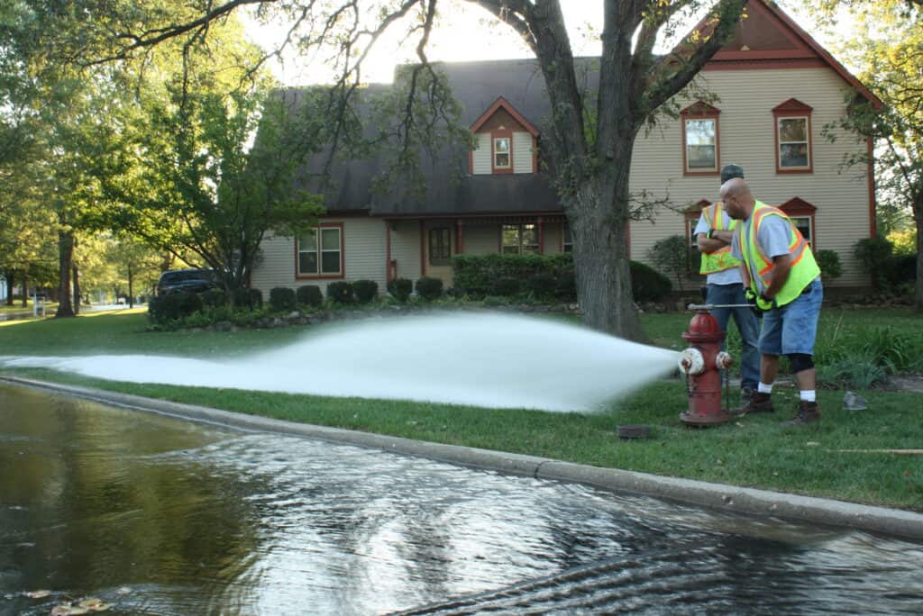 Water utility crews perform fire hydrant flushing in a residential neighborhood to help maintain a reliable drinking water distribution system