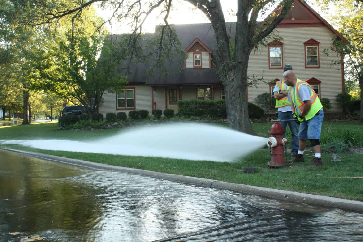 Water utility crews perform fire hydrant flushing in a residential neighborhood to help maintain a reliable drinking water distribution system